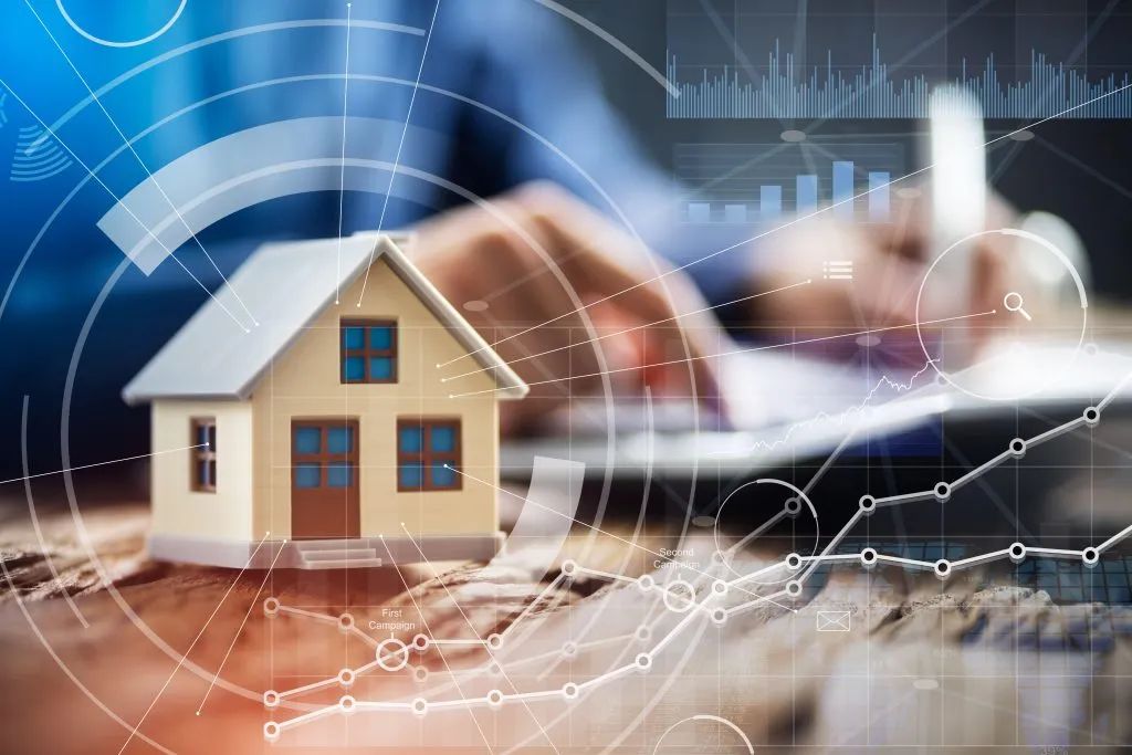 Close up Of A Person Hand Doing Property Tax Calculation With House Model On The Table